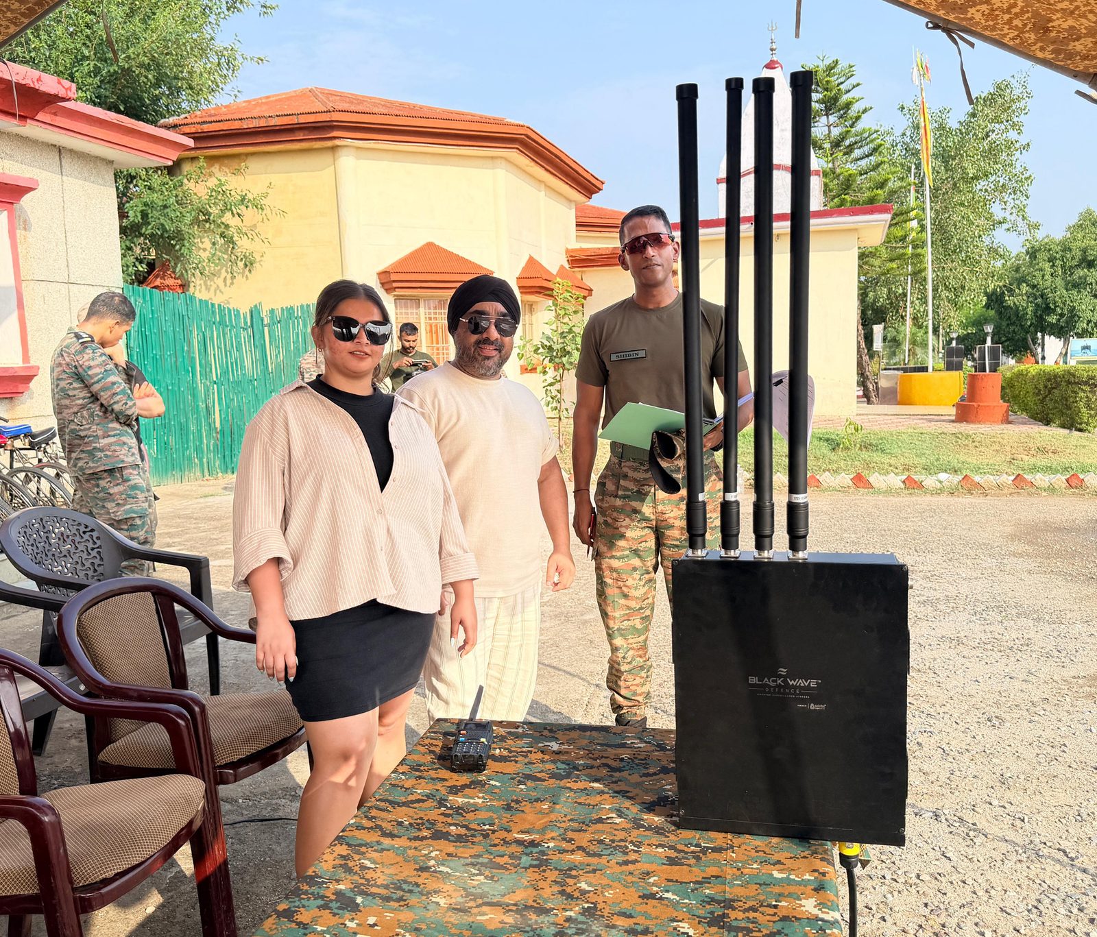 Team posing with a Black Wave Defence multi-antenna anti-drone jamming unit outdoors