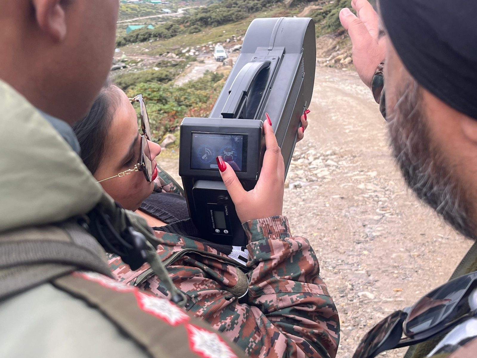 Close-up of a soldier operating the display screen on a handheld anti-drone jamming device