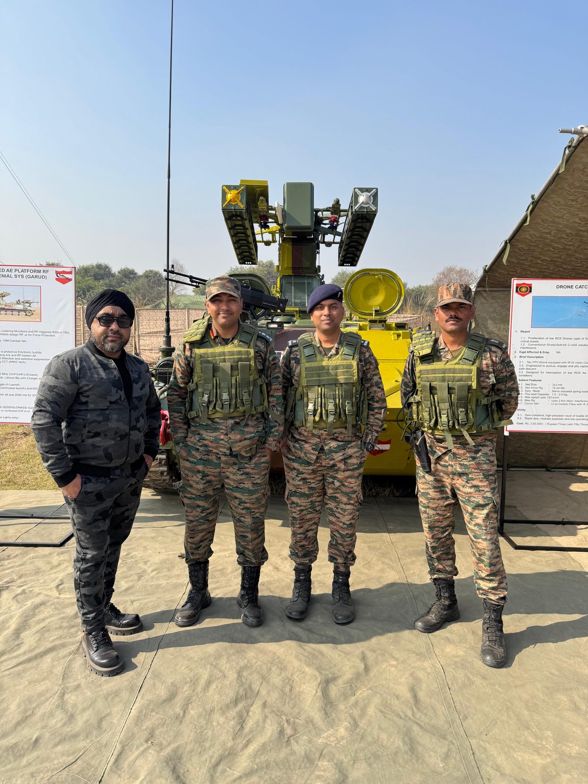 Team posing with a mobile radar and anti-drone vehicle system at a defence exhibition