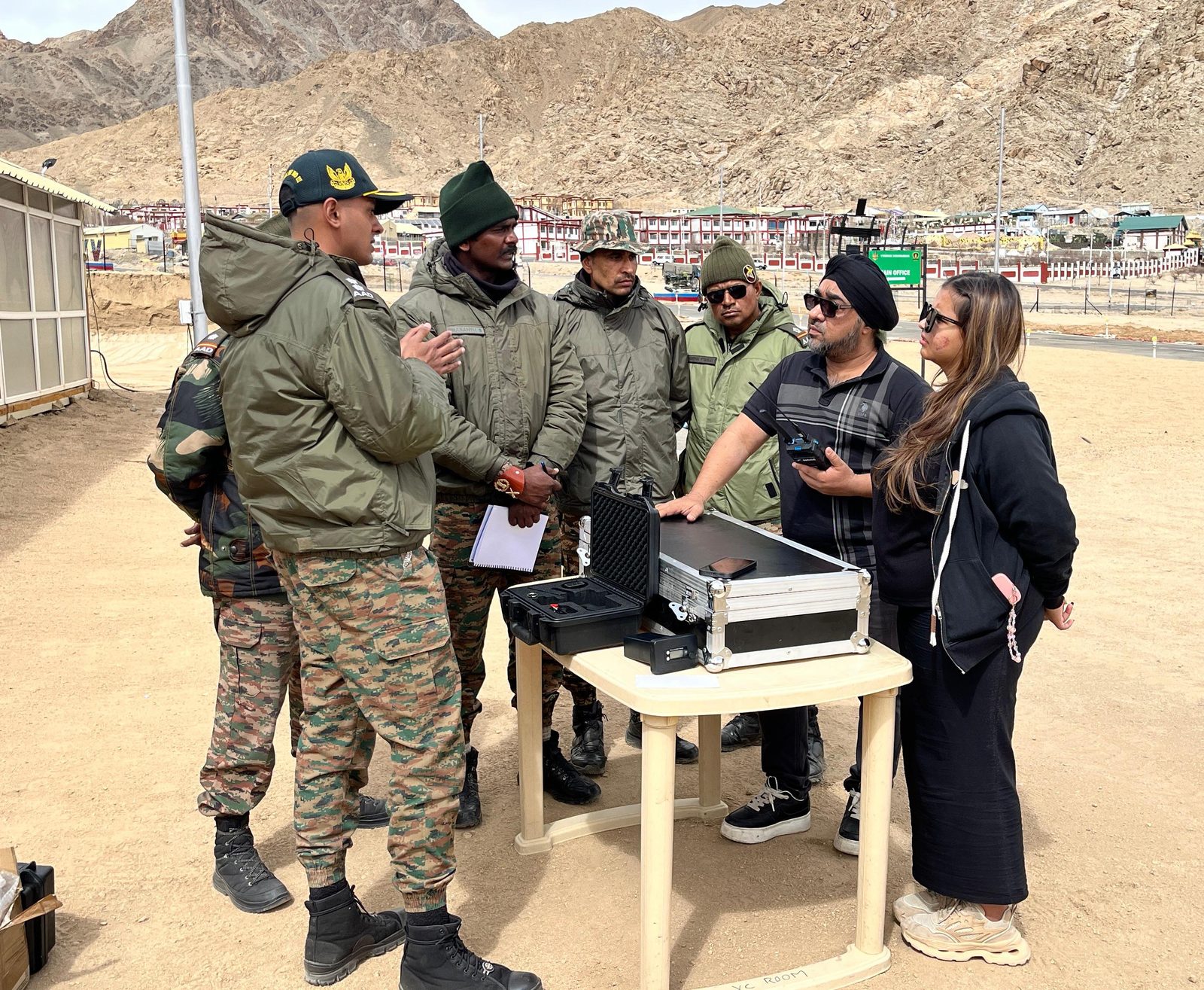 Soldiers and engineers reviewing anti-drone equipment at a mountain military base
